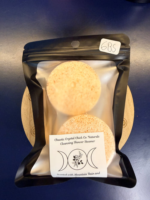 Two orange shower steamers in a black package on a blue background